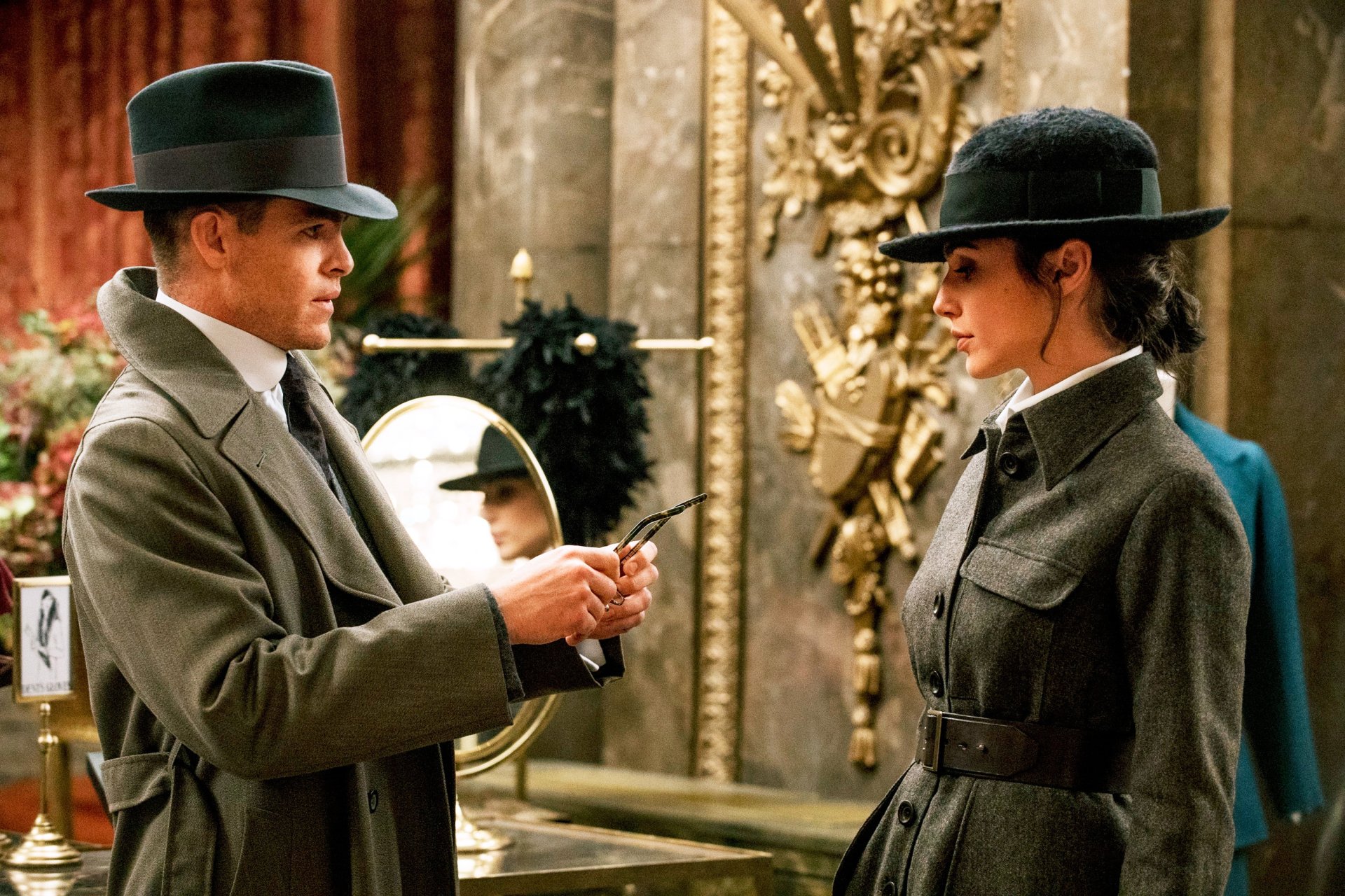 HD desktop wallpaper featuring Gal Gadot as Diana Prince and Chris Pine as Steve Trevor from the movie Wonder Woman, in a scene set indoors with elegant decor and both characters dressed in early 20th-century attire.