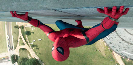 HD desktop wallpaper of Spider-Man climbing a wall from the movie Spider-Man: Homecoming, displaying the superhero in his iconic red and blue suit against an urban backdrop.