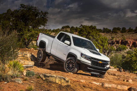 White Chevrolet Colorado ZR2 pickup on a rocky desert trail, off-road view of the Chevrolet vehicle — 2K Quad HD PC desktop wallpaper and background.