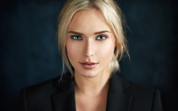 Portrait of a blonde woman with striking blue eyes, modeled by Eva Mikulski, set against a dark background for an HD PC desktop wallpaper.