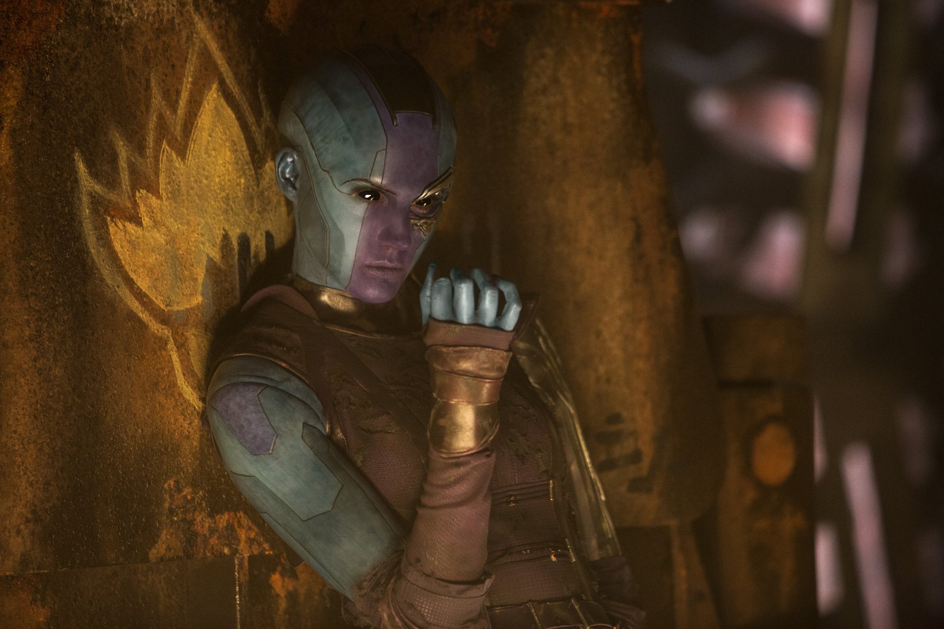 Nebula (Marvel Comics) from the movie Guardians of the Galaxy Vol. 2, blue cybernetic makeup posed against rusted machinery — 5K Ultra HD PC desktop wallpaper/background.