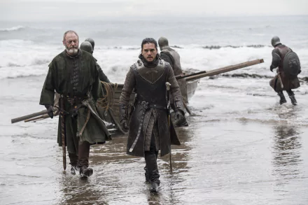 Game of Thrones: Jon Snow and Davos Seaworth stride ashore from a skiff on a gray, wet beach — 2K Quad HD desktop wallpaper.