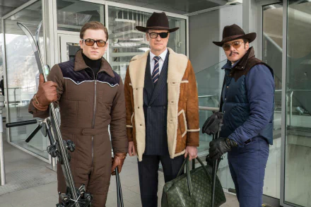 HD desktop wallpaper from the movie Kingsman: The Golden Circle featuring Pedro Pascal, Colin Firth, and Taron Egerton, dressed in stylish spy outfits, standing together with a mountainous background.