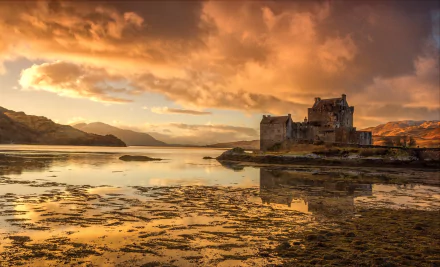 Eilean Donan Castle, a man-made stone castle on a Scottish lake, reflected in calm water under dramatic clouds — landscape HD PC desktop wallpaper background.