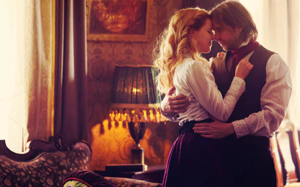 HD PC desktop wallpaper of the TV show 12 Monkeys: two characters embrace in a warmly lit, vintage parlor, an intimate, tense moment captured for a desktop background.