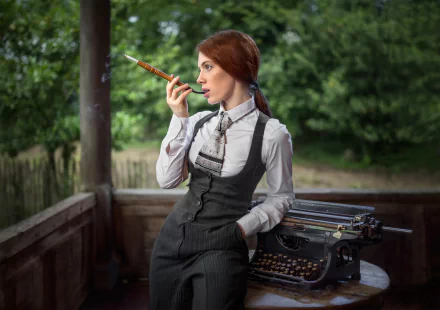 A red-haired woman smokes leisurely by an old typewriter in a rustic outdoor setting. The image features a depth of field effect, highlighting the model in an HD desktop wallpaper and background.