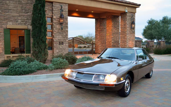 A classic Citroën SM 5-Speed car parked in front of a stone building, captured in 4K Ultra HD for a PC desktop wallpaper background.