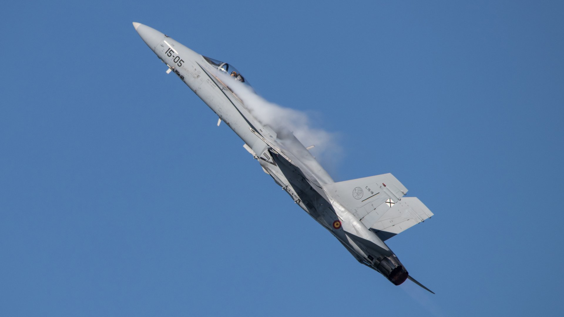 4K Ultra HD desktop wallpaper of a McDonnell Douglas F/A-18 Hornet jet fighter climbing with vapor trails against a clear blue sky.