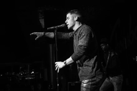 HD desktop wallpaper of a monochrome image featuring a male singer performing on stage, tagged as Nick Jonas.