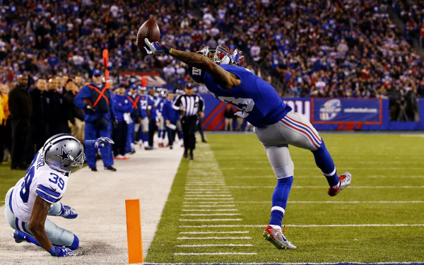 Odell Beckham Jr. makes an impressive one-handed catch during a game with the New York Giants, showcasing his athleticism in this dynamic sports wallpaper.