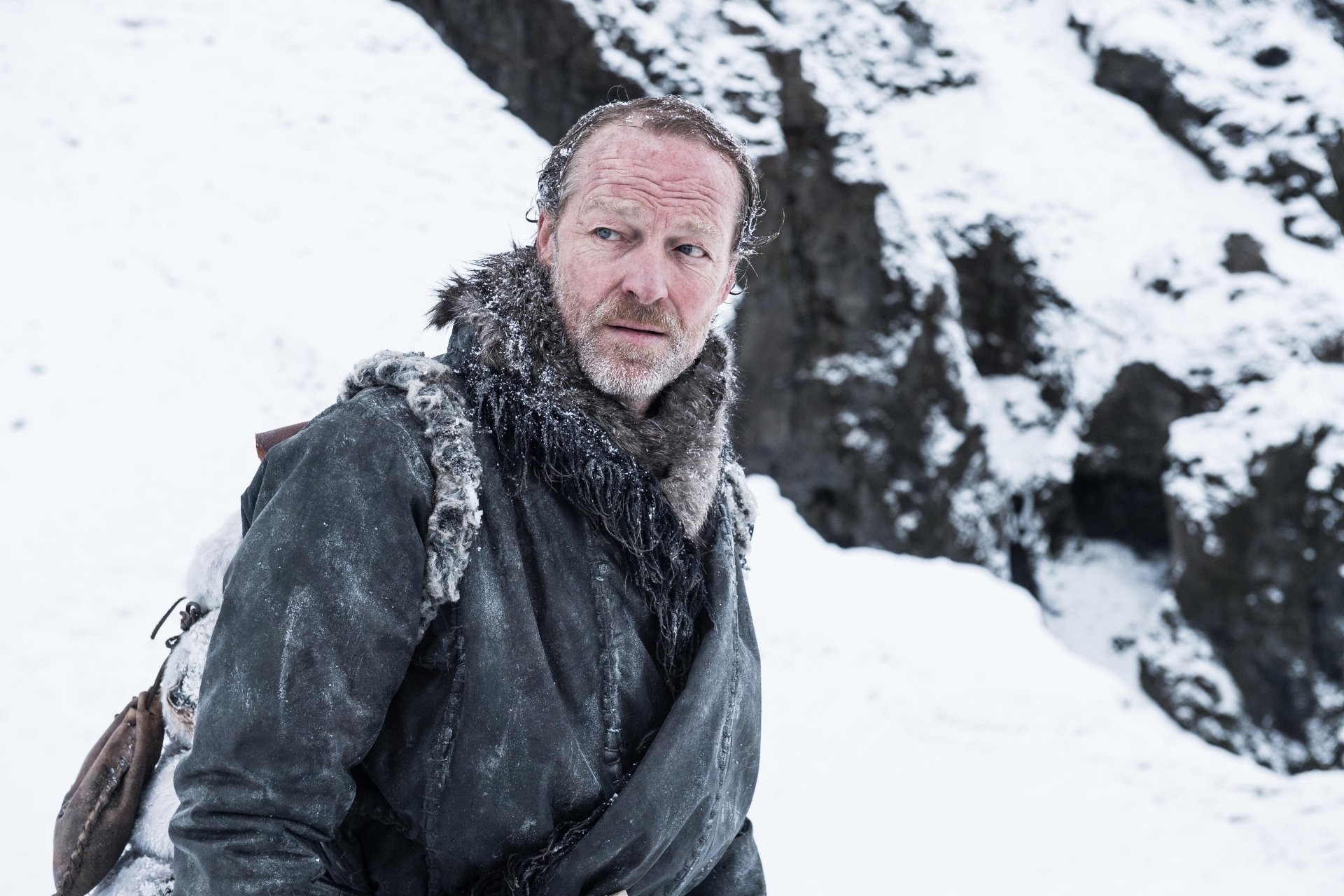 Jorah Mormont from the TV show Game of Thrones in a fur cloak on a snowy cliff — 5K Ultra HD PC desktop wallpaper.