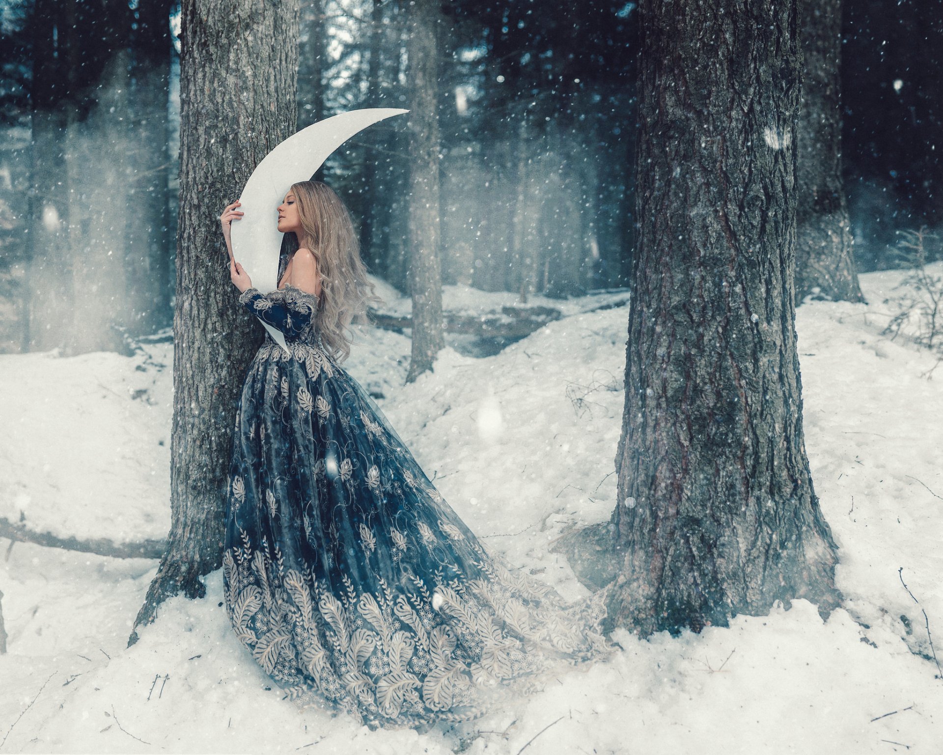 HD PC desktop wallpaper of a woman in an ornate gown holding a crescent moon umbrella amid falling snow in a fantasy winter forest background.