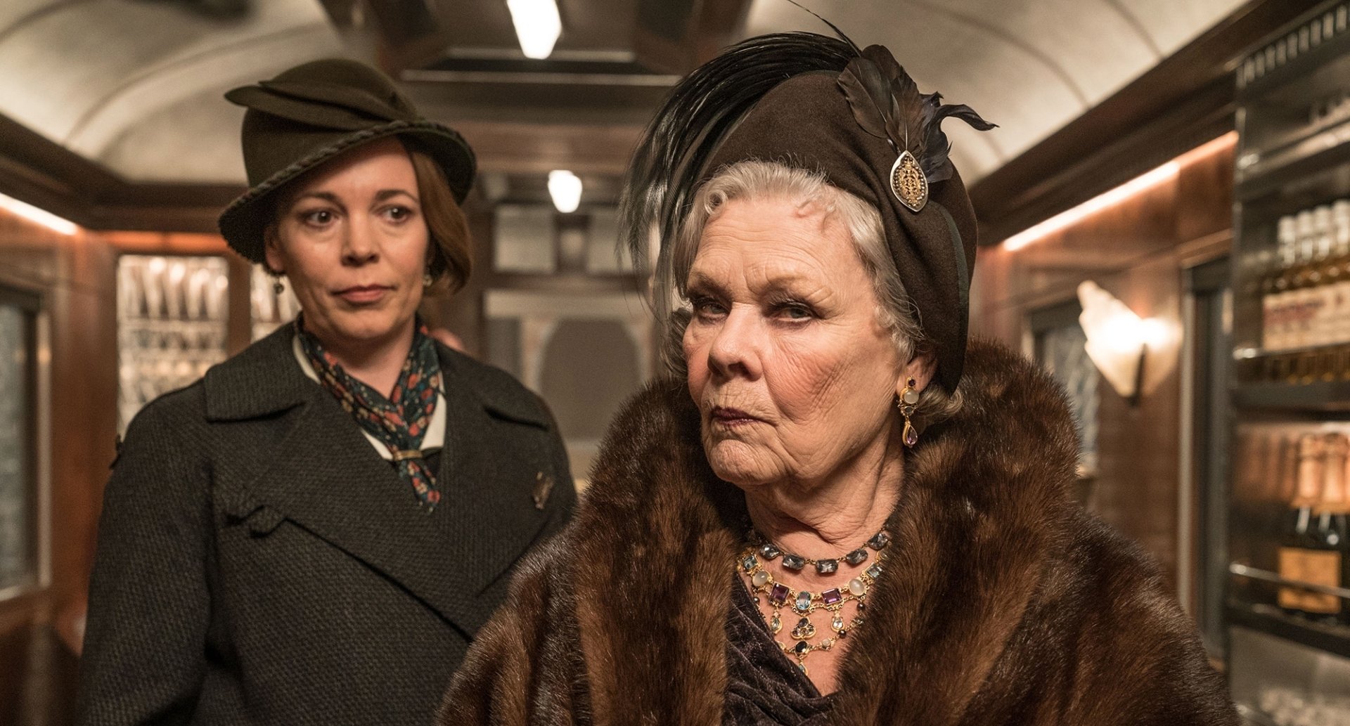 HD desktop wallpaper featuring a scene from the movie Murder on the Orient Express (2017) with Olivia Colman and Judi Dench in character on a train.