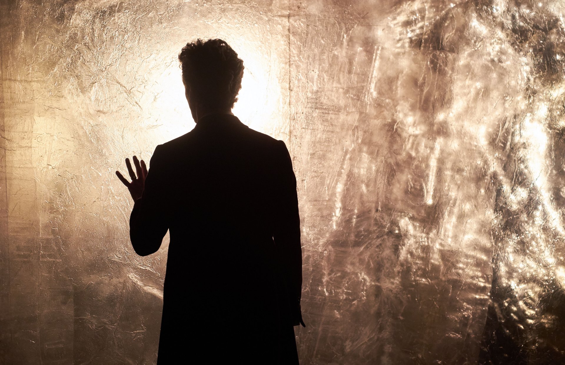 Silhouette of Peter Capaldi as the 12th Doctor from Doctor Who (2005) against a textured, illuminated background in 4K Ultra HD.