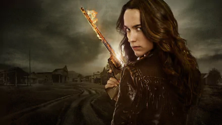 HD PC desktop wallpaper featuring Melanie Scrofano as Wynonna Earp, holding a glowing gun against a dark, stormy background from the TV show Wynonna Earp.