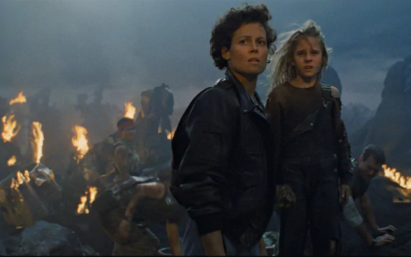 HD PC desktop wallpaper and background from the movie Alien: an adult woman in a leather jacket and a young girl stand amid burning wreckage, cinematic sci-fi composition.