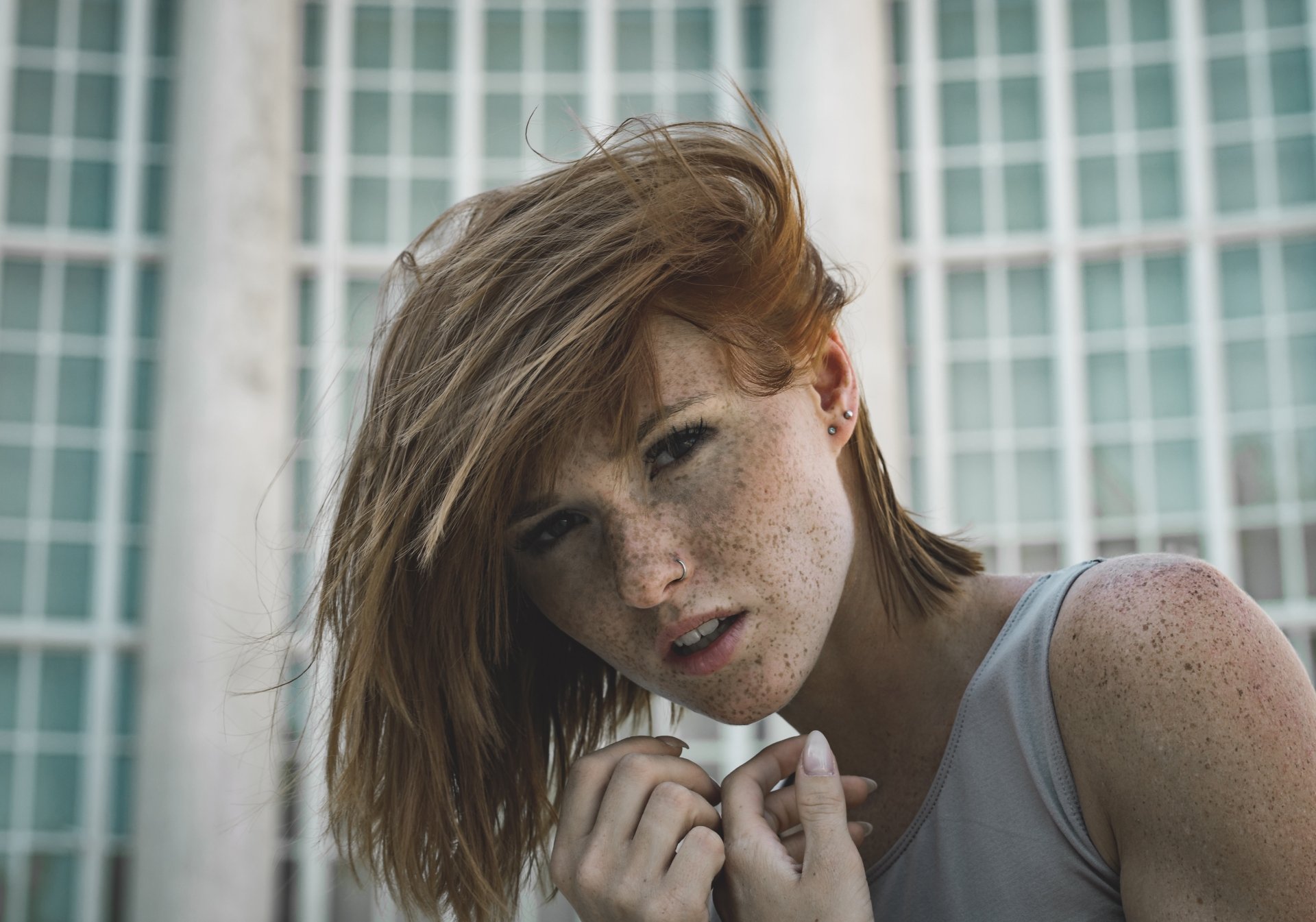 Freckled redhead woman model with windblown hair and a direct gaze, photographed as a 5K Ultra HD PC desktop wallpaper and background.