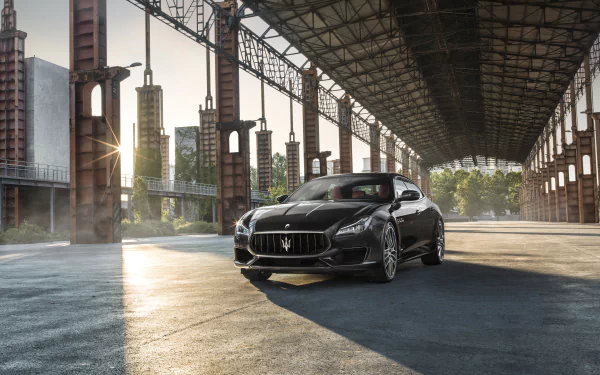 Silver Maserati Quattroporte parked beneath an industrial steel canopy at sunrise, dramatic shadows and reflections, 4K Ultra HD PC desktop car wallpaper/background.