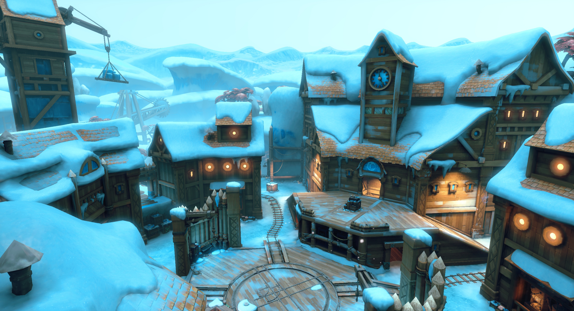 Paladins video game HD PC desktop wallpaper: snow-covered village map with clocktower, wooden buildings, icy rooftops, circular stone plaza and distant snowy mountains.