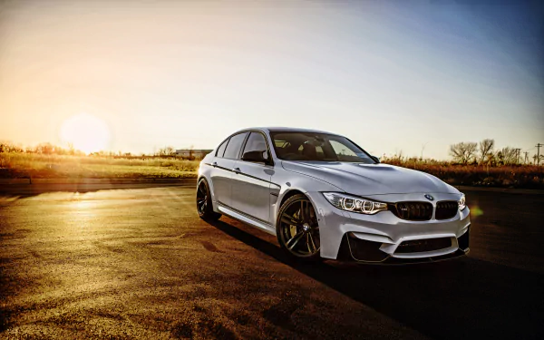 White BMW M3 parked on a sunlit asphalt surface during sunset, captured in stunning 4K Ultra HD as a desktop wallpaper and background.