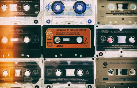 HD PC desktop wallpaper and background: music-themed collage of vintage cassette tapes in warm, retro tones with light leaks and textured grain.
