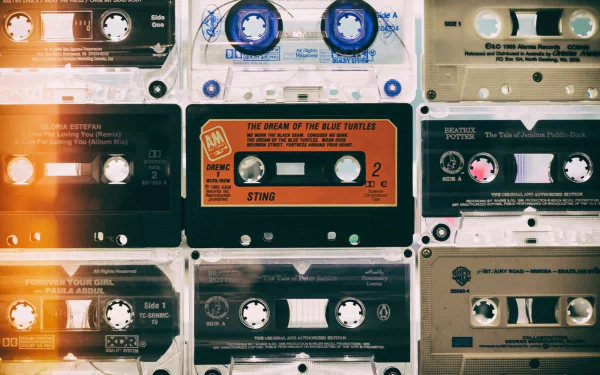 HD PC desktop wallpaper and background: music-themed collage of vintage cassette tapes in warm, retro tones with light leaks and textured grain.