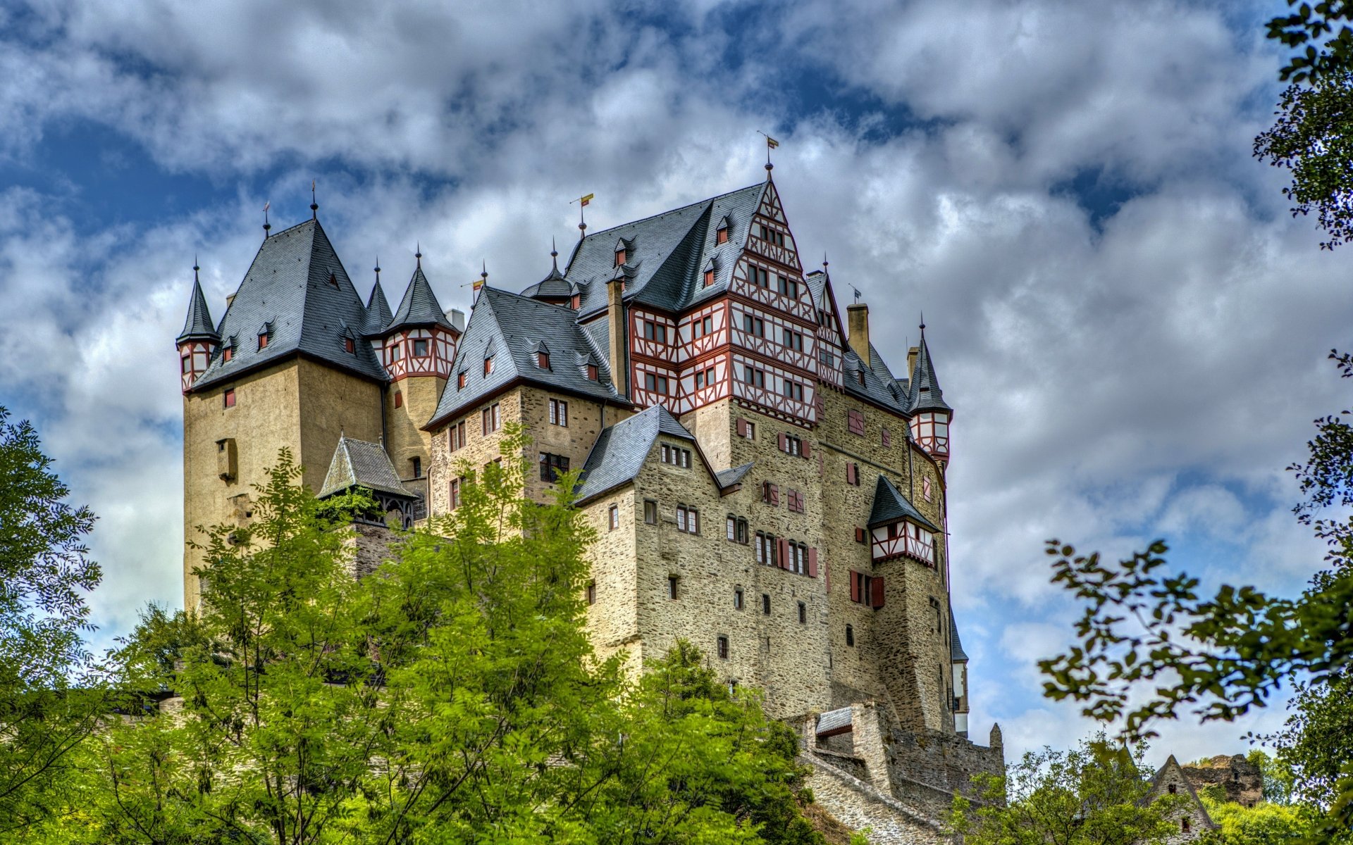 Eltz Castle, a striking man-made architectural landmark in Germany, stands majestically against a vibrant sky, captured in 4K Ultra HD for a stunning desktop wallpaper.