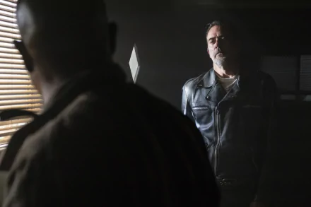Negan from The Walking Dead in a leather jacket confronts a silhouetted man in a dim, moody 4K TV show wallpaper.