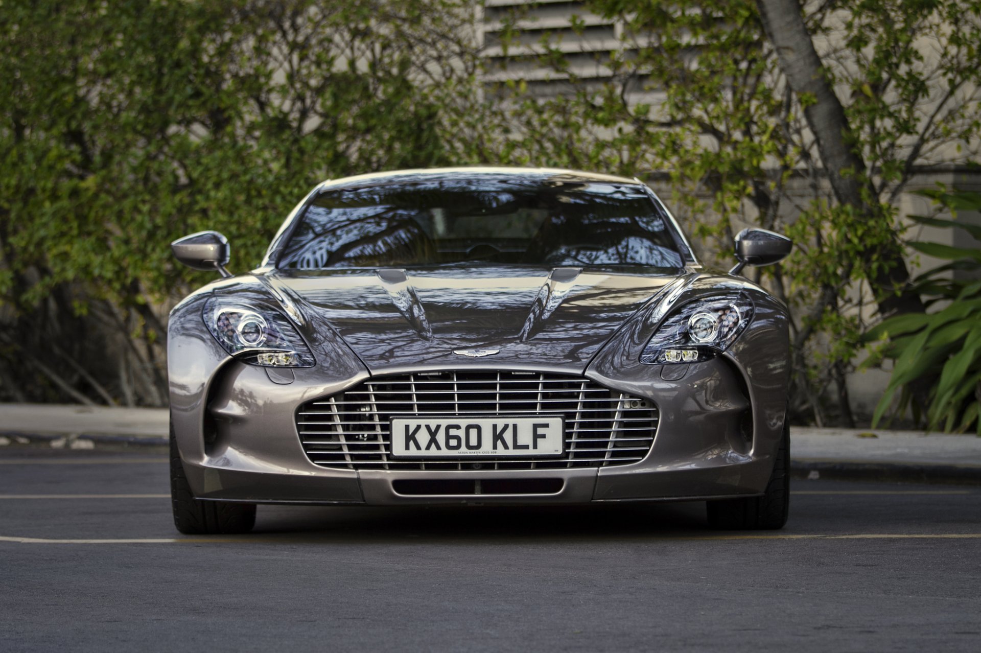 Front view of a silver Aston Martin One-77 coupé supercar, parked vehicle with chrome grille and license plate visible; HD PC desktop wallpaper/background.