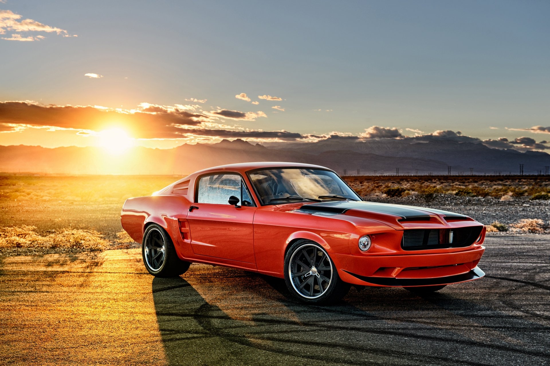 A red Ford Mustang Fastback muscle car parked on a desert road at sunset, captured in stunning 4K Ultra HD for a vibrant PC desktop wallpaper.