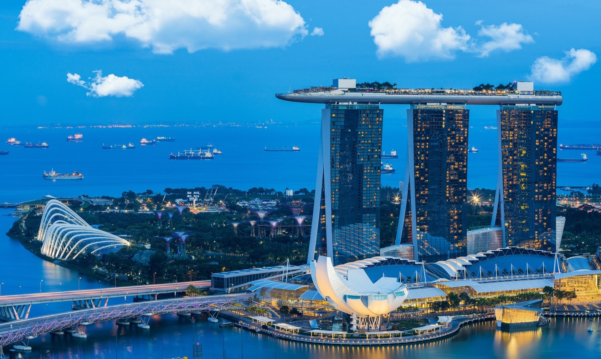 Night view of Marina Bay Sands skyscraper and surrounding buildings in Singapore, showcasing a vibrant cityscape with illuminated architecture and calm waters.