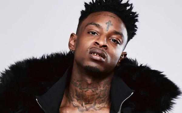 HD desktop wallpaper featuring a photo of a man with tattoos and a fur-collared jacket, tagged as 21 Savage.