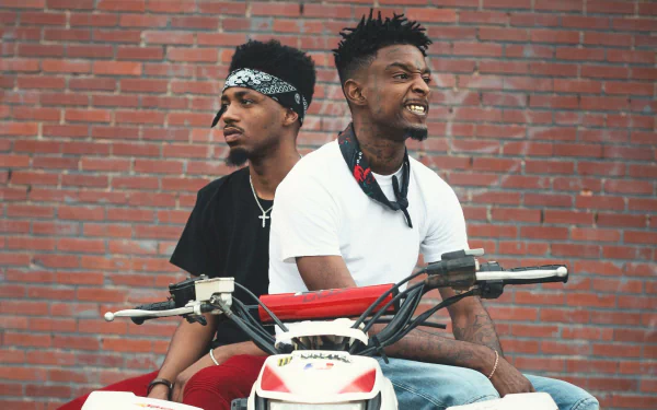 HD desktop wallpaper featuring two individuals on a motorbike against a brick wall background, tagged with 21 Savage.