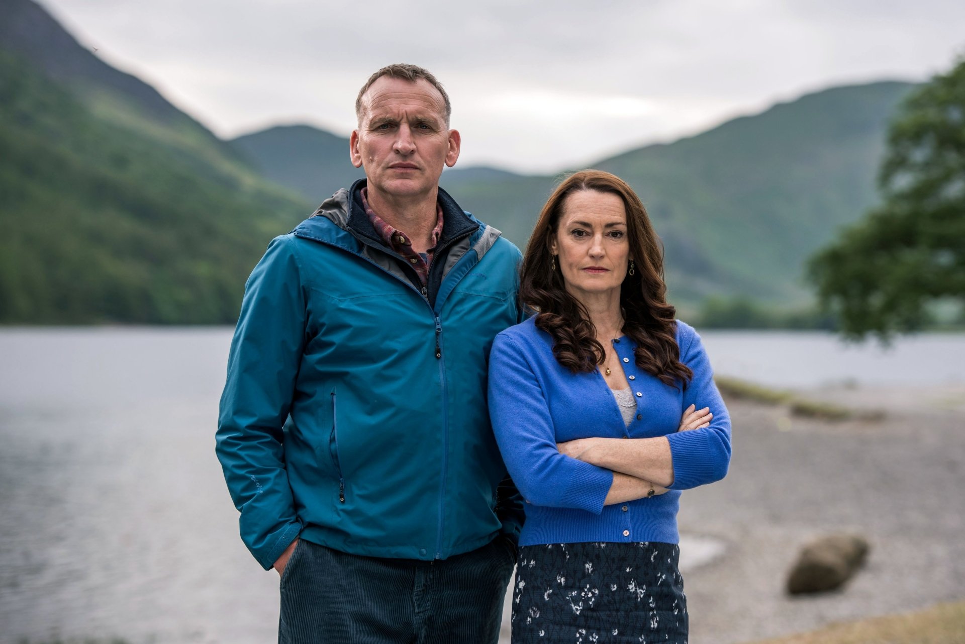 The A Word series characters posing confidently before a lake and mountains, as an HD desktop wallpaper background.