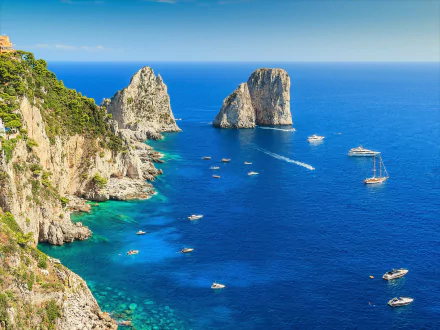 Turquoise sea and rugged coastline of Amalfi, Italy, with boats sailing near rocky cliffs under a clear horizon, captured in vibrant HD photography.