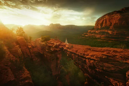 HD PC desktop wallpaper background showing a woman model in a flowing white dress standing on a red rock natural bridge at sunset overlooking a vast canyon.