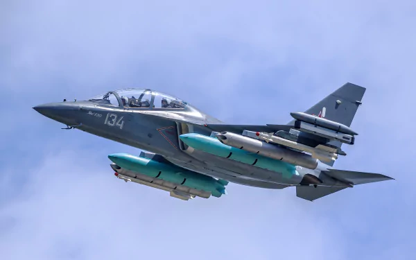 HD desktop wallpaper featuring a Yakovlev Yak-130 military jet fighter warplane in flight against a clear blue sky.
