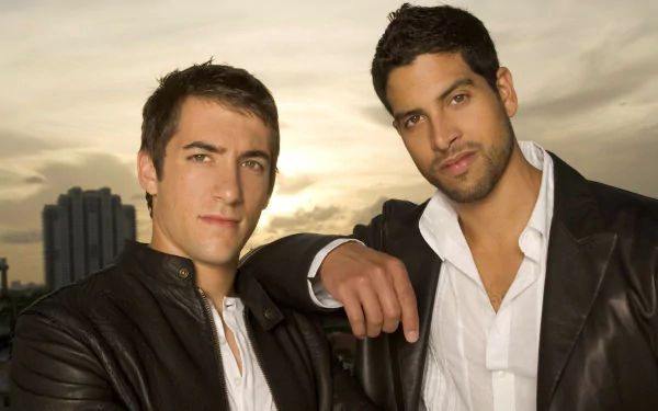 HD PC desktop wallpaper featuring two main characters from the TV show CSI: Miami posing in front of a sunset cityscape.