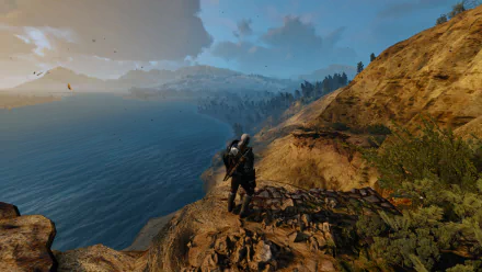 Geralt of Rivia stands on a rocky cliff overlooking a vast ocean at sunset in an 8K Ultra HD desktop wallpaper from the video game The Witcher 3: Wild Hunt.