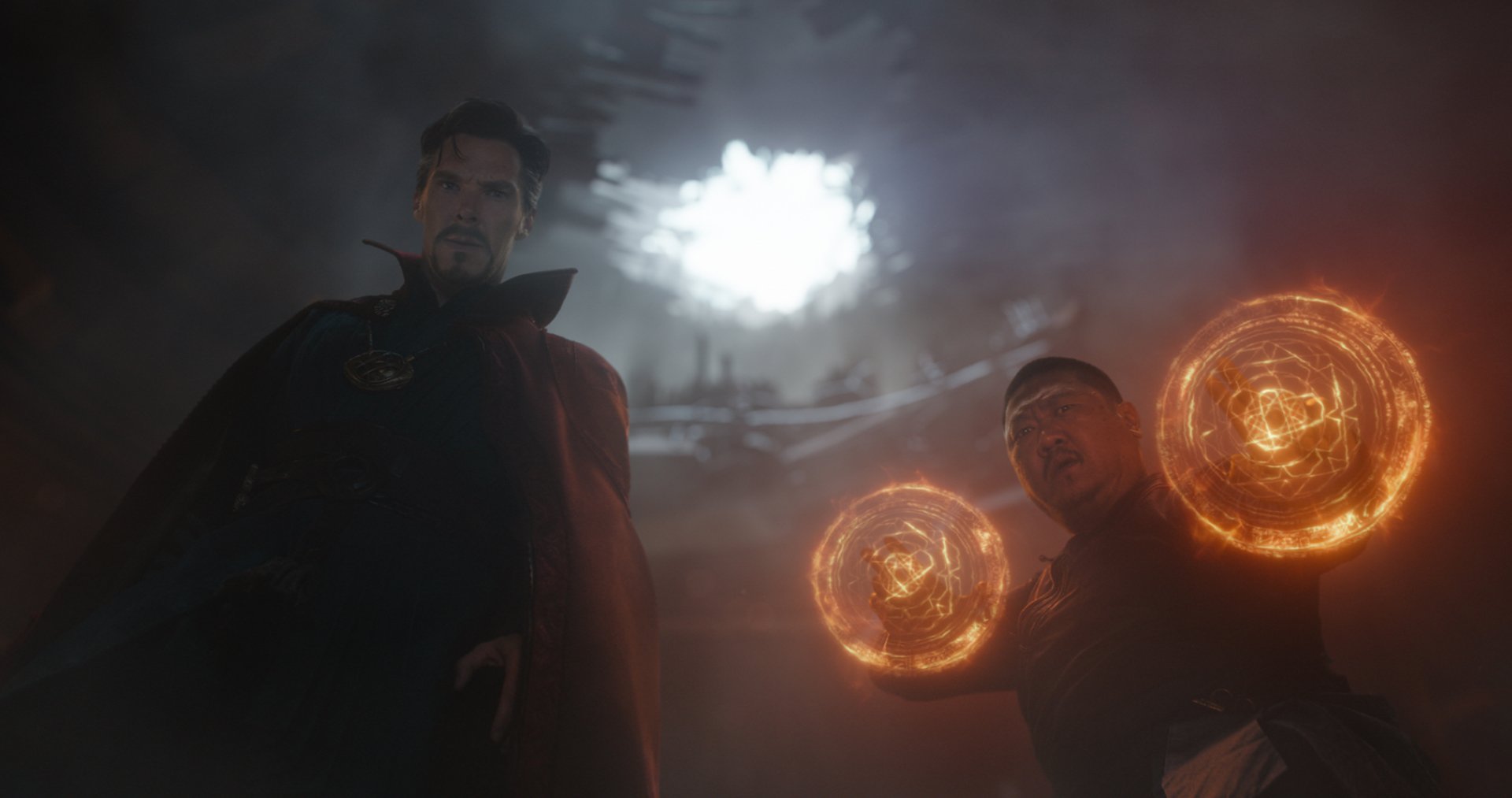 Benedict Cumberbatch as Doctor Strange and Benedict Wong as Wong in a dramatic scene from Avengers: Infinity War, featuring mystical energy effects, set against a dark and intense backdrop.