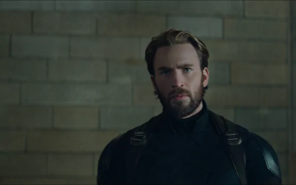 HD wallpaper featuring Chris Evans as Captain America (Steve Rogers) from the movie Avengers: Infinity War. Evans is seen in his superhero costume against a brick wall background.
