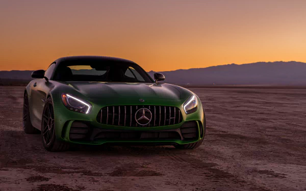 A green Mercedes-AMG GT supercar parked on a desert landscape at sunset, captured in 4K Ultra HD for a striking desktop wallpaper.
