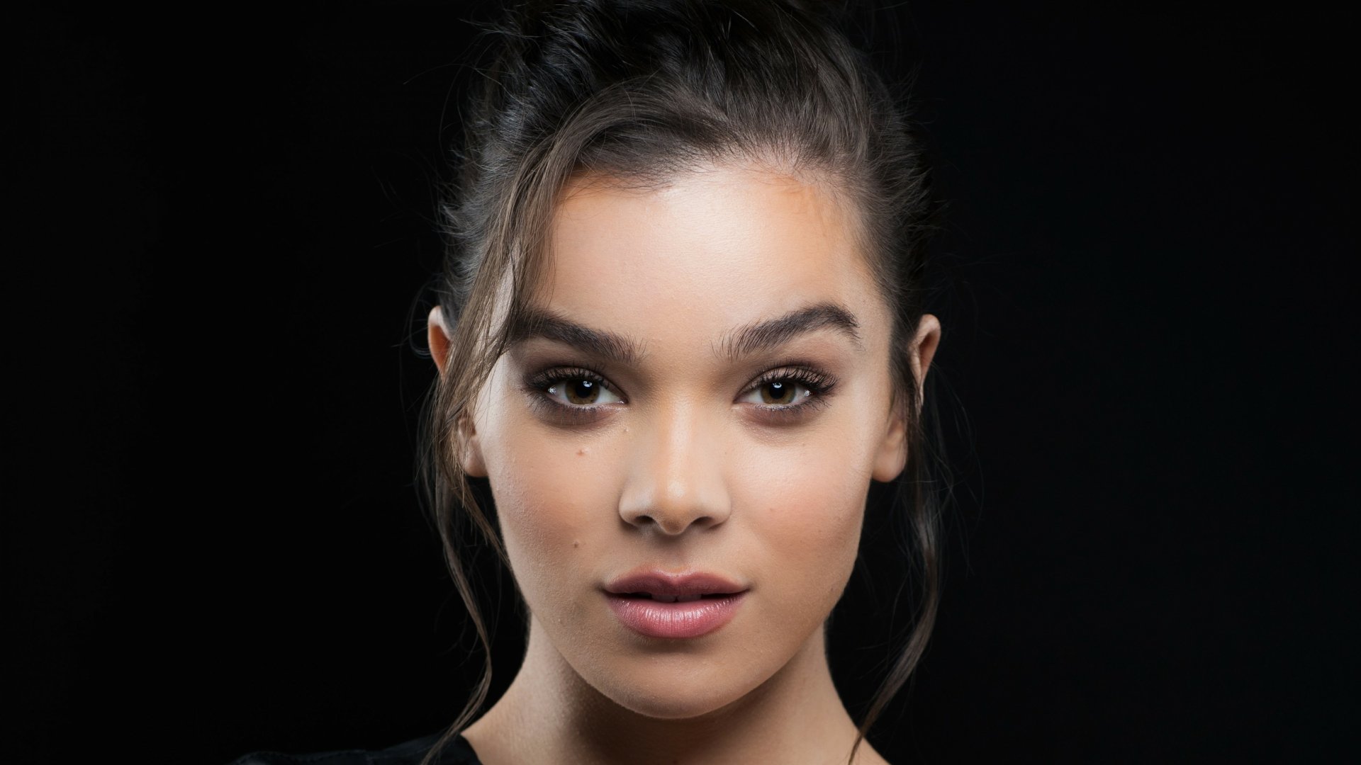 Close-up 4K Ultra HD portrait of brunette celebrity Hailee Steinfeld with brown eyes, captured in sharp detail for PC desktop wallpaper and background.