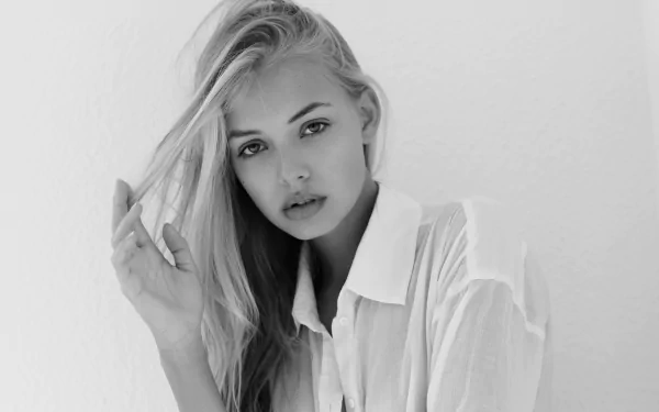 Monochrome black and white portrait of a female model with long hair, styled simply, set against a plain background in 4K Ultra HD quality.