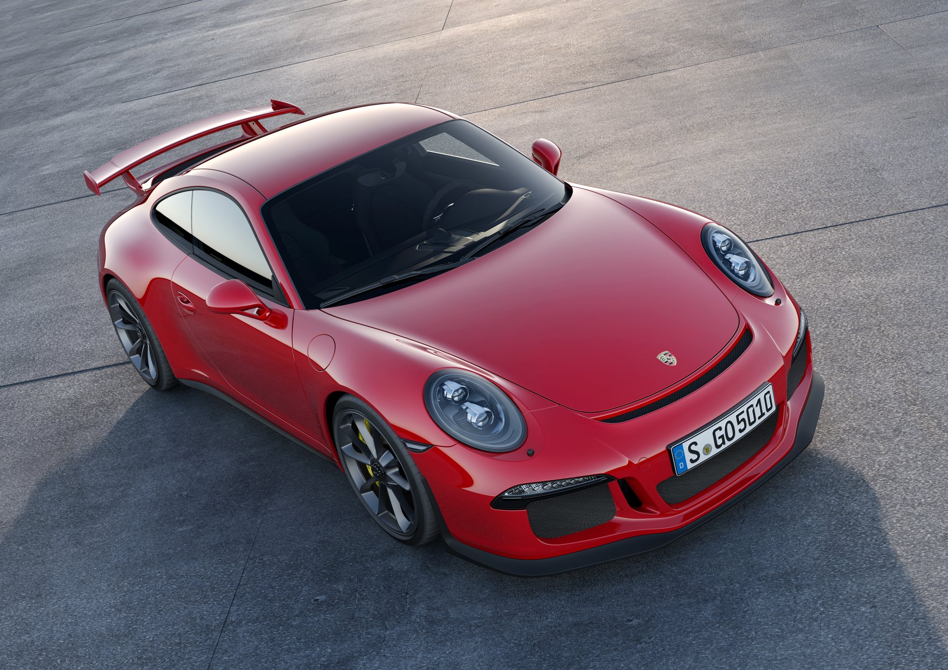 A stunning HD desktop wallpaper image of a red Porsche 911 GT3 parked on a concrete surface. The car's sleek design and aerodynamic features are prominently highlighted.