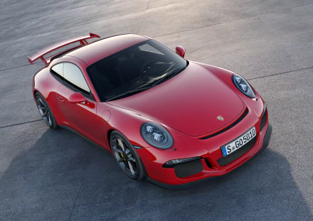 A stunning HD desktop wallpaper image of a red Porsche 911 GT3 parked on a concrete surface. The car's sleek design and aerodynamic features are prominently highlighted.
