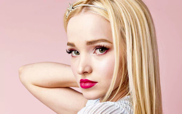 Close-up portrait of American singer and actress Dove Cameron with blonde hair and bold lipstick against a soft pink background, 4K Ultra HD wallpaper.