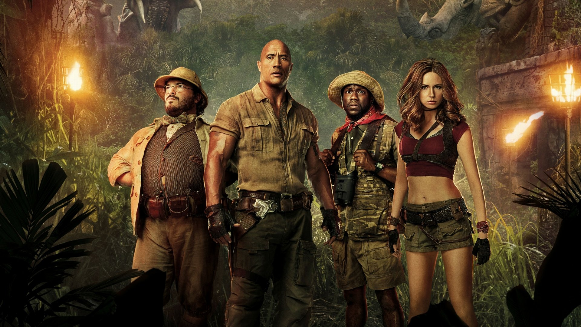A HD desktop wallpaper featuring Karen Gillan, Jack Black, Kevin Hart, and Dwayne Johnson posing in their adventure gear from the movie Jumanji: Welcome to the Jungle, set against a lush jungle background.