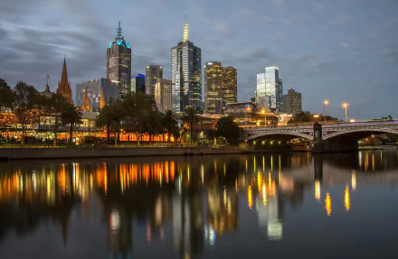 Night view of Melbourne’s city skyline with illuminated skyscrapers reflecting on the Yarra River, showcasing man-made architectural beauty in Australia.