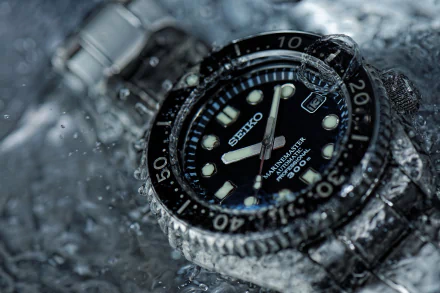 Close-up of a Seiko dive watch with water droplets on the bezel and bracelet, HD man-made timepiece shown as a PC desktop wallpaper and background.